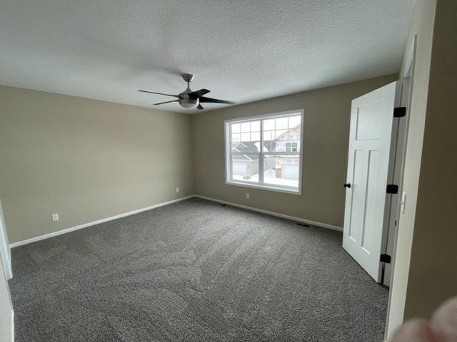 1027 45th Ave NE, Saint Cloud, MN 56304 - spare room with a ceiling fan, baseboards, dark colored carpet, and a textured ceiling