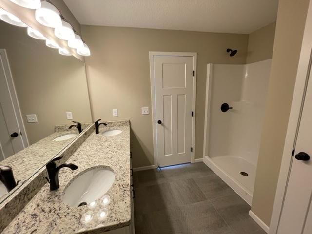 1027 45th Ave NE, Saint Cloud, MN 56304 - full bathroom with double vanity, baseboards, and a shower