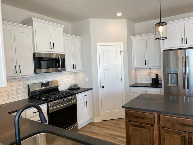 16695 Manor Rd, Eden Prairie, MN 55343 - kitchen with appliances with stainless steel finishes, dark countertops, wood finished floors, white cabinets, and recessed lighting
