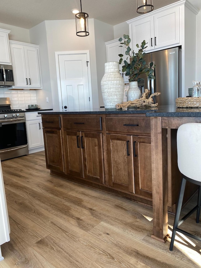 16695 Manor Rd, Eden Prairie, MN 55343 - kitchen featuring appliances with stainless steel finishes, dark countertops, light wood-style floors, and white cabinets