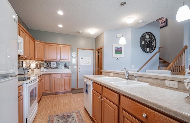 10465 172nd Ln NW, Elk River, MN 55330 - kitchen featuring white appliances, a sink, a textured ceiling, light wood-style flooring, and light countertops