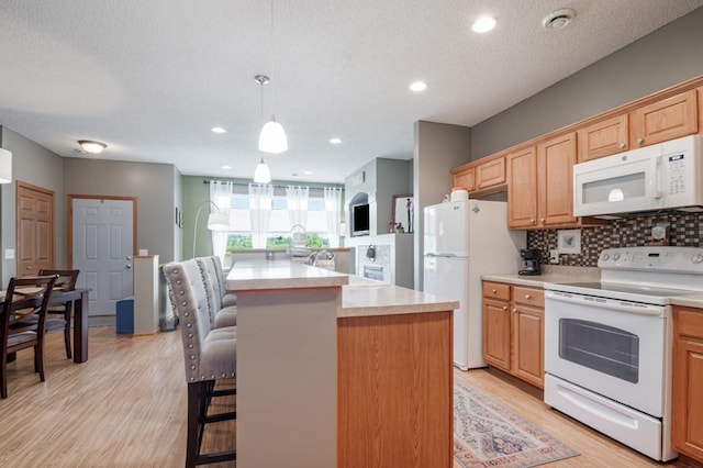 10465 172nd Ln NW, Elk River, MN 55330 - kitchen featuring white appliances, backsplash, a kitchen bar, light countertops, and light wood finished floors