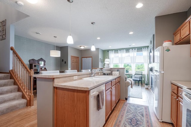 10465 172nd Ln NW, Elk River, MN 55330 - kitchen featuring dishwasher, a sink, a kitchen island with sink, light countertops, and light wood-style flooring