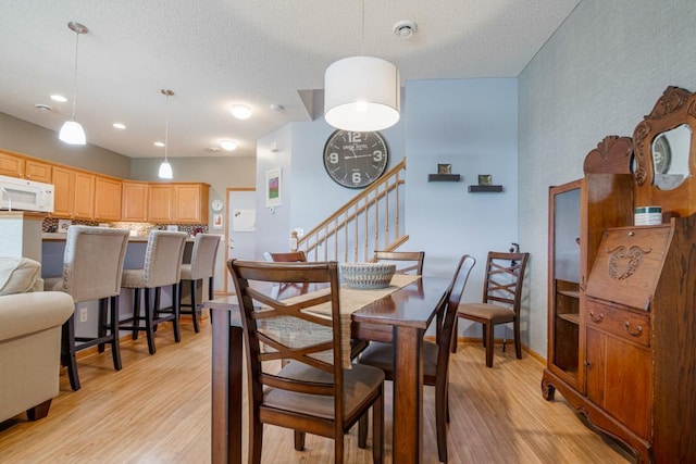 10465 172nd Ln NW, Elk River, MN 55330 - dining room with light wood-style floors, stairs, and a textured ceiling