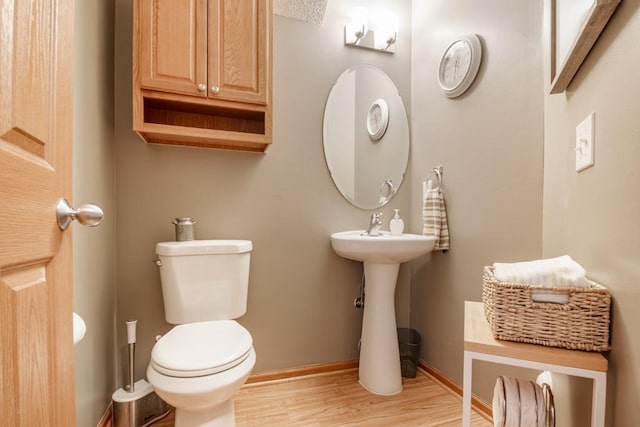 10465 172nd Ln NW, Elk River, MN 55330 - bathroom featuring wood finished floors, toilet, baseboards, and a sink