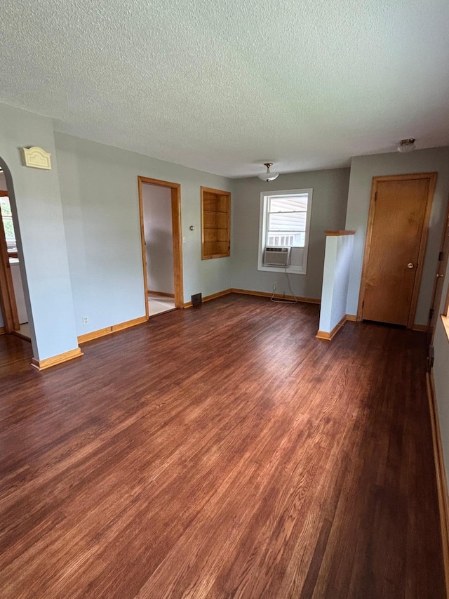912 Arnold Ave N, Thief River Falls, MN 56701 - spare room with arched walkways, a textured ceiling, dark wood-style floors, and baseboards