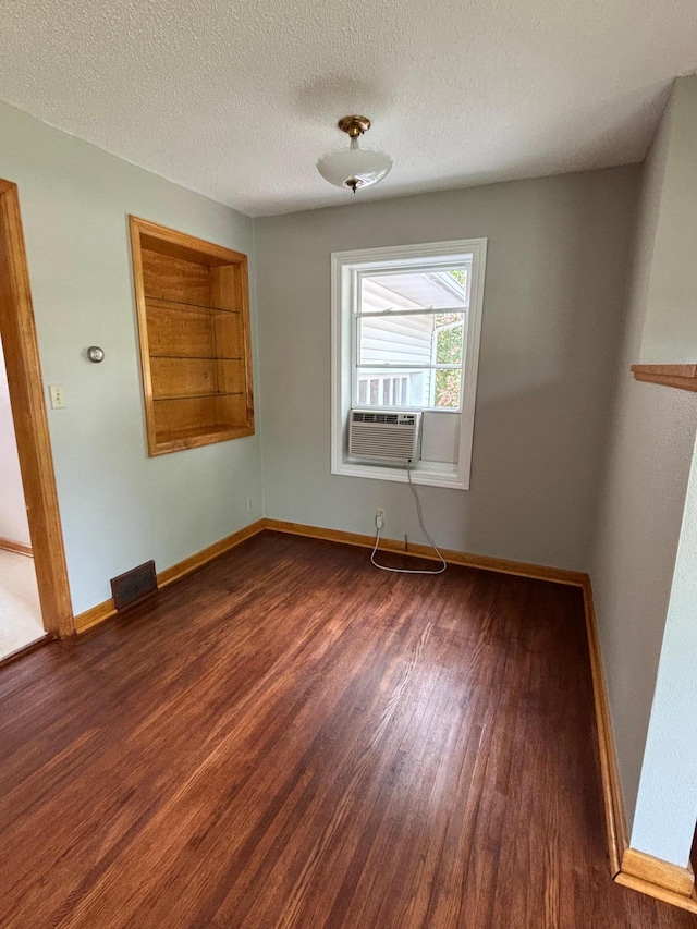 912 Arnold Ave N, Thief River Falls, MN 56701 - spare room with wood finished floors, cooling unit, baseboards, and a textured ceiling