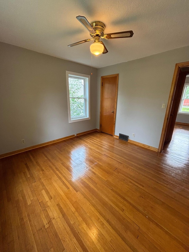 912 Arnold Ave N, Thief River Falls, MN 56701 - empty room featuring light wood-style floors, plenty of natural light, a ceiling fan, and baseboards
