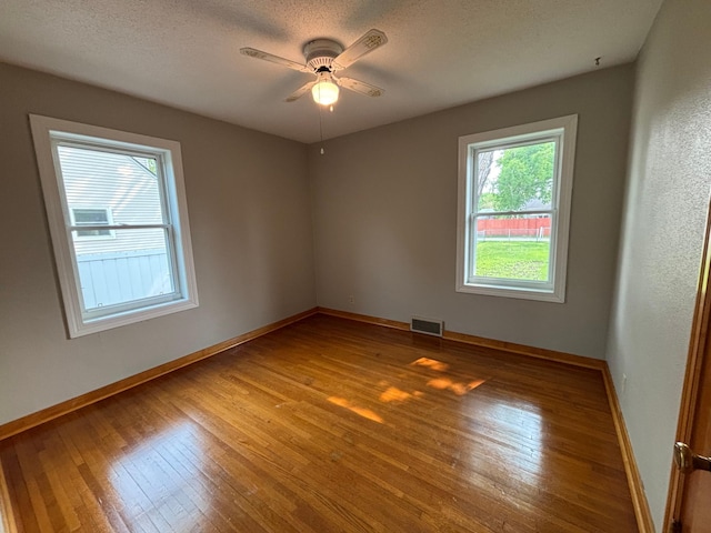 912 Arnold Ave N, Thief River Falls, MN 56701 - spare room with hardwood / wood-style floors, baseboards, a ceiling fan, and a textured ceiling