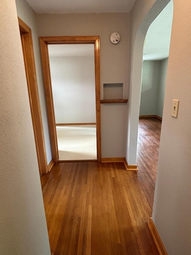 912 Arnold Ave N, Thief River Falls, MN 56701 - corridor featuring wood finished floors, arched walkways, and baseboards