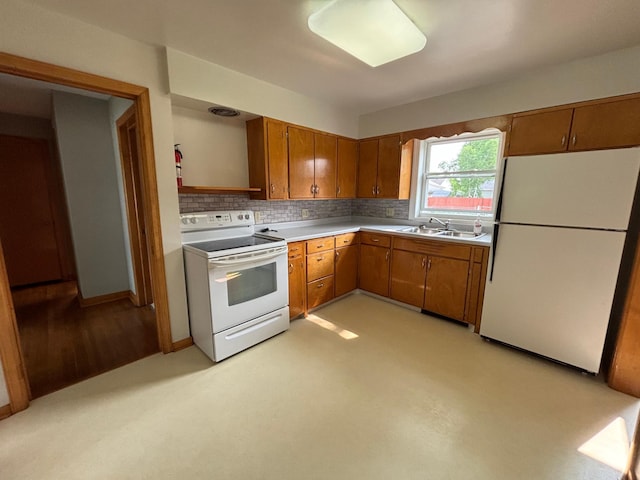 912 Arnold Ave N, Thief River Falls, MN 56701 - kitchen with white appliances, brown cabinets, light countertops, tasteful backsplash, and a sink