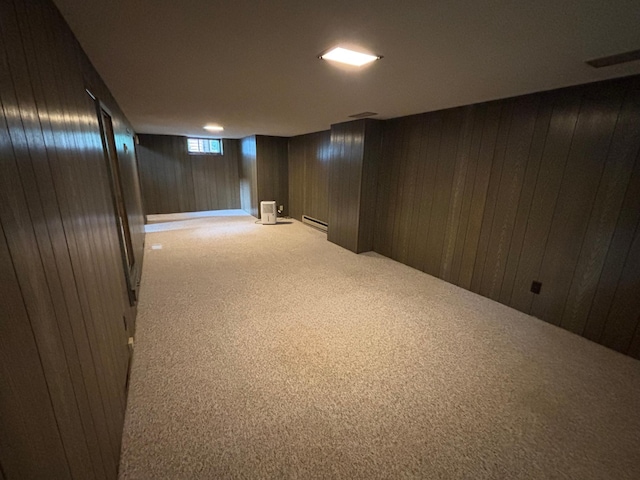 912 Arnold Ave N, Thief River Falls, MN 56701 - below grade area featuring light carpet, wooden walls, and a baseboard heating unit