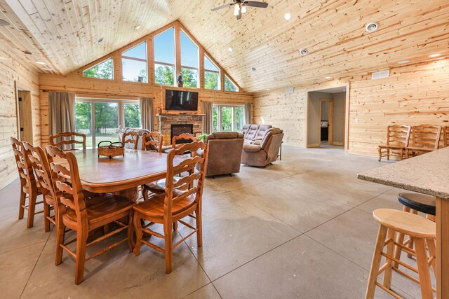 20470 220th St, Verndale, MN 56481 - dining area featuring high vaulted ceiling, a fireplace, a ceiling fan, wooden walls, and concrete flooring