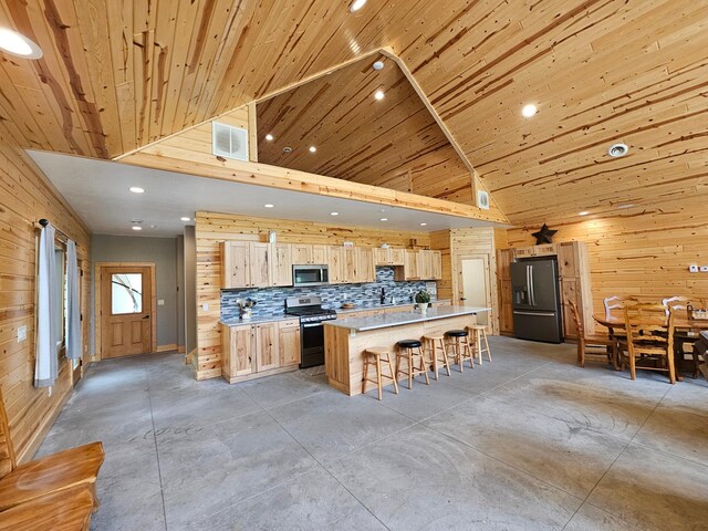 20470 220th St, Verndale, MN 56481 - kitchen featuring stainless steel appliances, light brown cabinetry, concrete flooring, wood walls, and recessed lighting