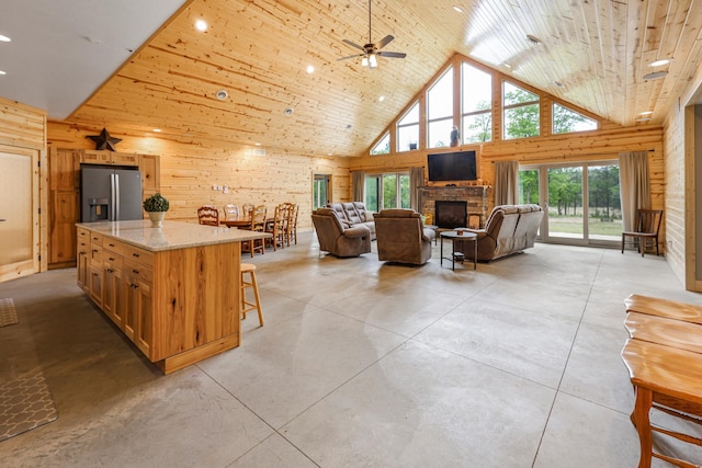 20470 220th St, Verndale, MN 56481 - living room featuring high vaulted ceiling, a ceiling fan, concrete floors, wood walls, and a stone fireplace