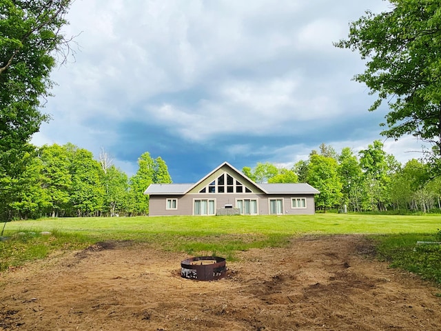 20470 220th St, Verndale, MN 56481 - back of house with a fire pit, a yard, and metal roof