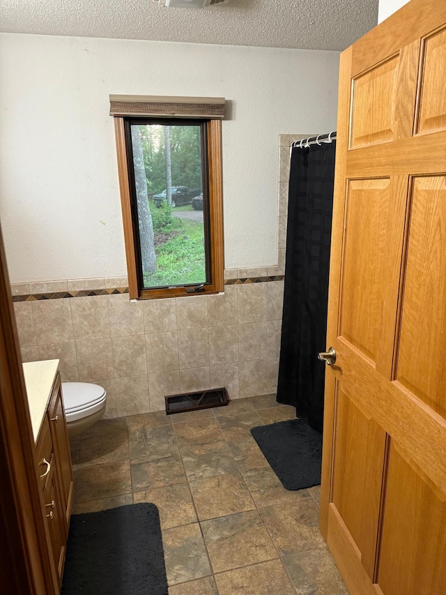 33688 416th Ave, Farm Island Twp, MN 56431 - full bath with vanity, a textured ceiling, toilet, tile walls, and curtained shower