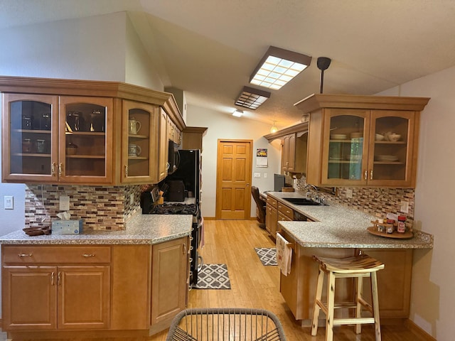 33688 416th Ave, Farm Island Twp, MN 56431 - kitchen with gas stove, a sink, vaulted ceiling, backsplash, and glass insert cabinets