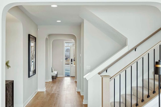 6552 Timber Arch Dr, Chaska, MN 55318 - hallway featuring arched walkways, recessed lighting, wood finished floors, stairs, and baseboards