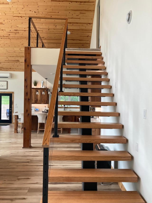 51509 County Highway 9, Scambler Twp, MN 56572 - stairs with a towering ceiling, wood finished floors, wooden ceiling, and an AC wall unit