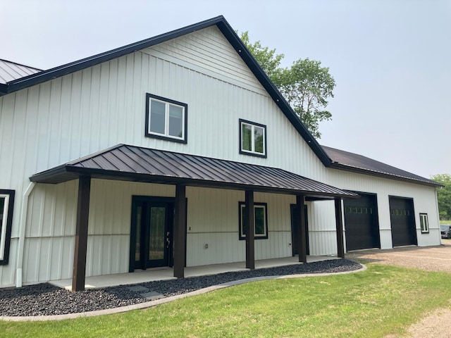 51509 County Highway 9, Scambler Twp, MN 56572 - rear view of property with a standing seam roof, covered porch, a garage, metal roof, and a lawn