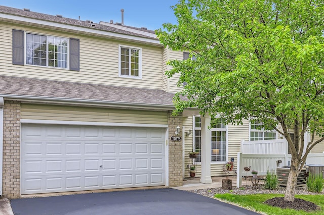 17673 96th Ave N, Maple Grove, MN 55311 - view of front facade with driveway, roof with shingles, an attached garage, and brick siding