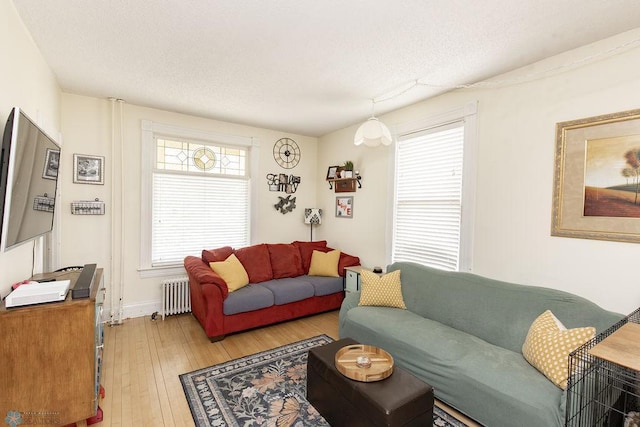 108 6th Ave N, Fargo, ND 58102 - living area featuring radiator, light wood-style floors, and a textured ceiling