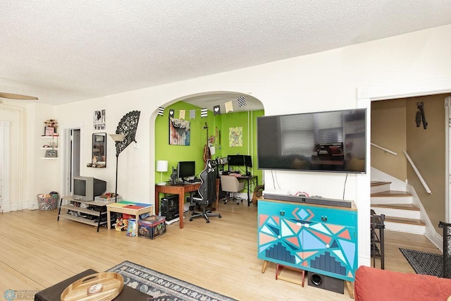 108 6th Ave N, Fargo, ND 58102 - living area featuring arched walkways, wood finished floors, a textured ceiling, a desk, and stairway