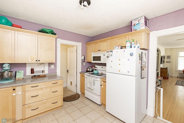 108 6th Ave N, Fargo, ND 58102 - kitchen featuring white appliances, light brown cabinetry, light tile patterned floors, light countertops, and a textured ceiling