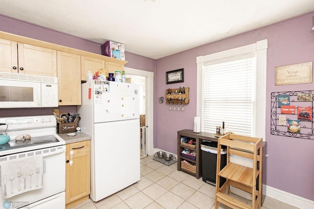 108 6th Ave N, Fargo, ND 58102 - kitchen with white appliances, light brown cabinetry, light tile patterned flooring, light countertops, and baseboards