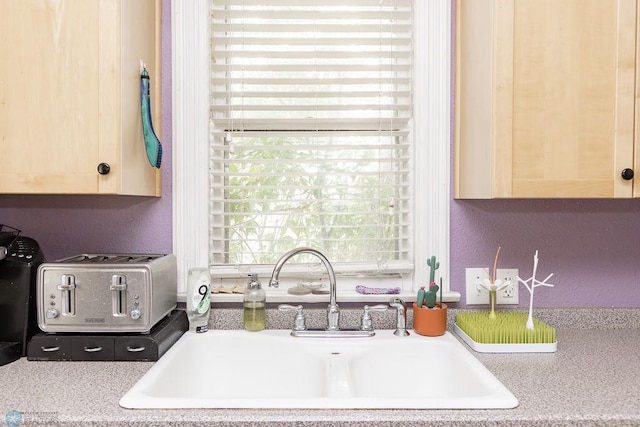108 6th Ave N, Fargo, ND 58102 - kitchen with a sink, light brown cabinetry, a textured wall, and light countertops