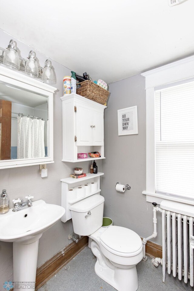 108 6th Ave N, Fargo, ND 58102 - bathroom featuring radiator heating unit, toilet, and a sink