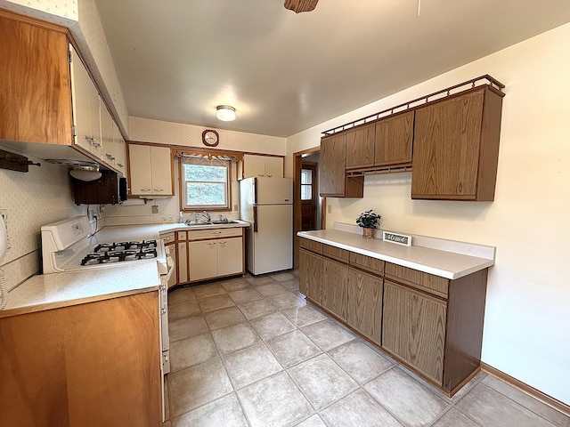 1620 4th St, Montevideo, MN 56265 - kitchen featuring freestanding refrigerator, range with gas stovetop, light countertops, and a sink