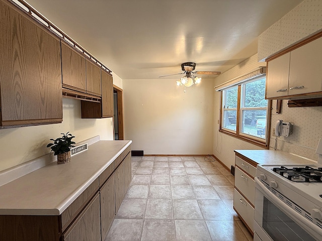 1620 4th St, Montevideo, MN 56265 - kitchen with gas range gas stove, light countertops, a ceiling fan, wallpapered walls, and baseboards