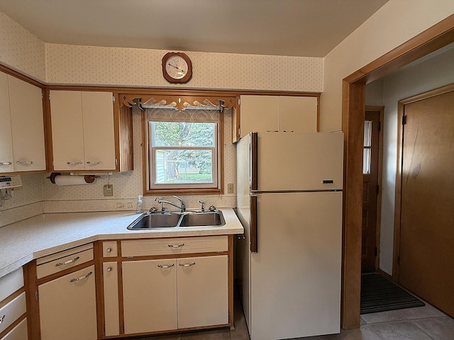 1620 4th St, Montevideo, MN 56265 - kitchen featuring freestanding refrigerator, a sink, light countertops, wallpapered walls, and cream cabinets