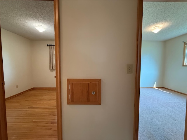 1620 4th St, Montevideo, MN 56265 - corridor with a textured ceiling, baseboards, and light wood-style floors