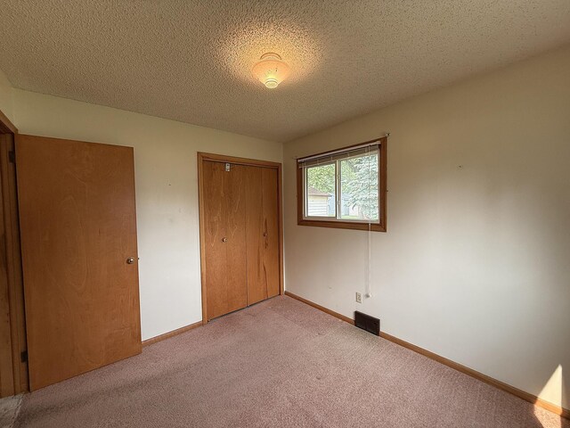 1620 4th St, Montevideo, MN 56265 - unfurnished bedroom with a closet, carpet, a textured ceiling, and baseboards