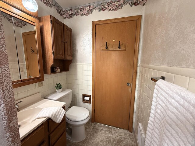 1620 4th St, Montevideo, MN 56265 - bathroom featuring tile walls, vanity, toilet, a wainscoted wall, and a textured wall