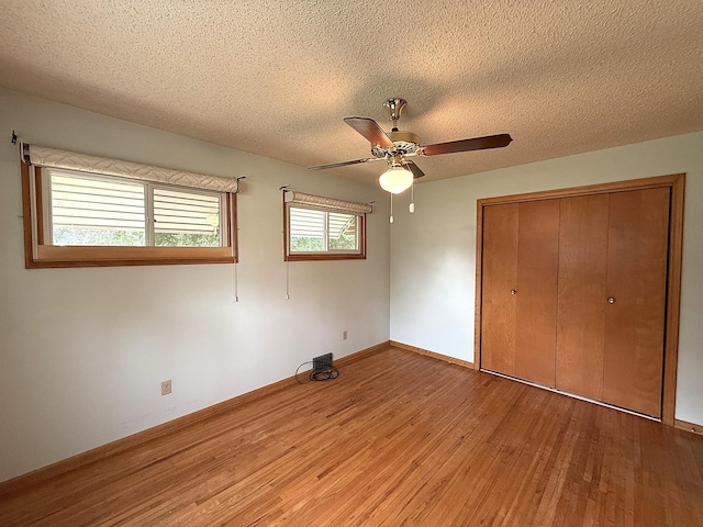 1620 4th St, Montevideo, MN 56265 - unfurnished bedroom featuring light wood-style floors, a textured ceiling, a closet, a ceiling fan, and baseboards