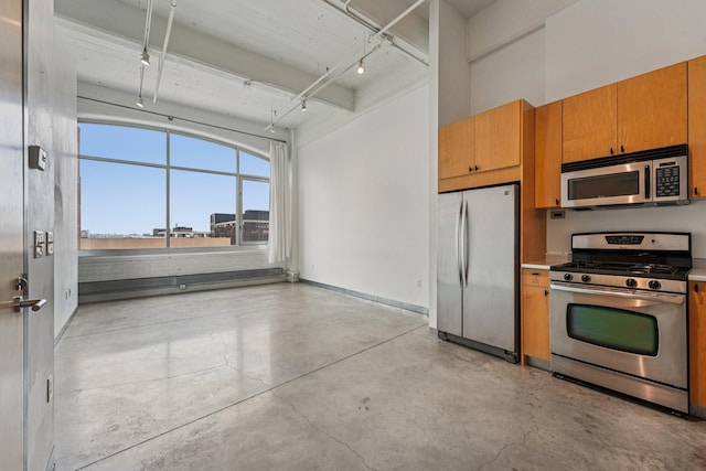 700 Washington Ave N Unit 601, Minneapolis, MN 55401 - kitchen with appliances with stainless steel finishes, concrete flooring, track lighting, brown cabinetry, and light countertops