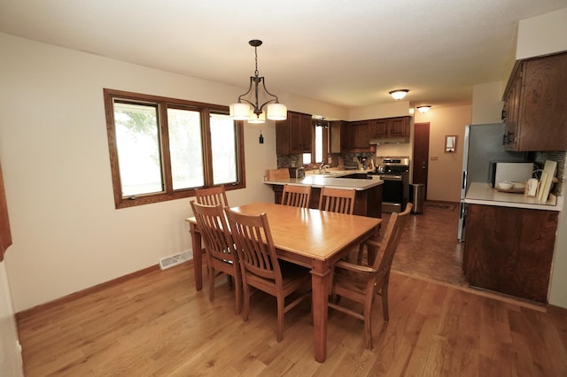 2805 12th Ave NW, Willmar, MN 56201 - dining space featuring light wood-style flooring, baseboards, and a chandelier