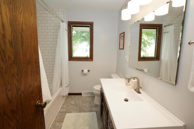 2805 12th Ave NW, Willmar, MN 56201 - full bathroom with vanity, stone finish flooring, toilet, baseboards, and shower / bathtub combination with curtain