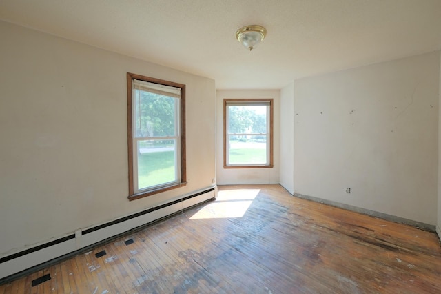 5741 Maple St, Rockford, MN 55373 - unfurnished room featuring a baseboard heating unit, hardwood / wood-style flooring, and baseboards