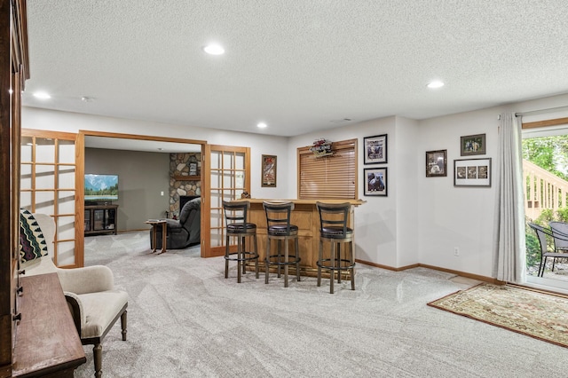 22774 Olivine St NW, Nowthen, MN 55330 - indoor dry bar with carpet, a textured ceiling, recessed lighting, baseboards, and a stone fireplace