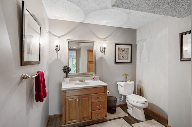 22774 Olivine St NW, Nowthen, MN 55330 - half bathroom featuring toilet, vanity, a textured ceiling, wood finished floors, and baseboards