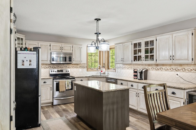 22774 Olivine St NW, Nowthen, MN 55330 - kitchen with appliances with stainless steel finishes, a sink, decorative backsplash, and light stone countertops