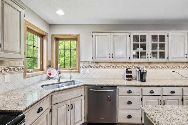 22774 Olivine St NW, Nowthen, MN 55330 - kitchen with stainless steel dishwasher, a sink, glass insert cabinets, backsplash, and light stone countertops