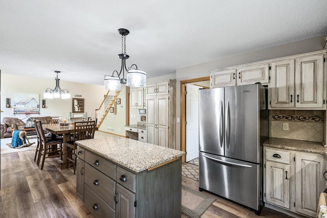 22774 Olivine St NW, Nowthen, MN 55330 - kitchen with freestanding refrigerator, dark wood-type flooring, backsplash, a kitchen island, and decorative light fixtures