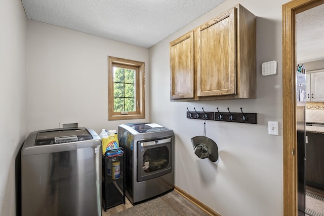 22774 Olivine St NW, Nowthen, MN 55330 - washroom with separate washer and dryer, cabinet space, a textured ceiling, wood finished floors, and baseboards