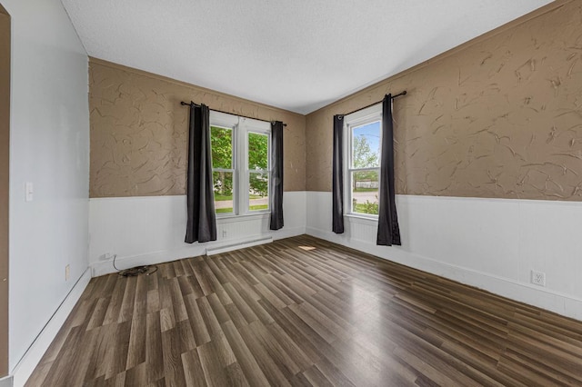 300 Ellington St, West Concord, MN 55985 - spare room with a wainscoted wall, wood finished floors, a baseboard heating unit, and a textured ceiling